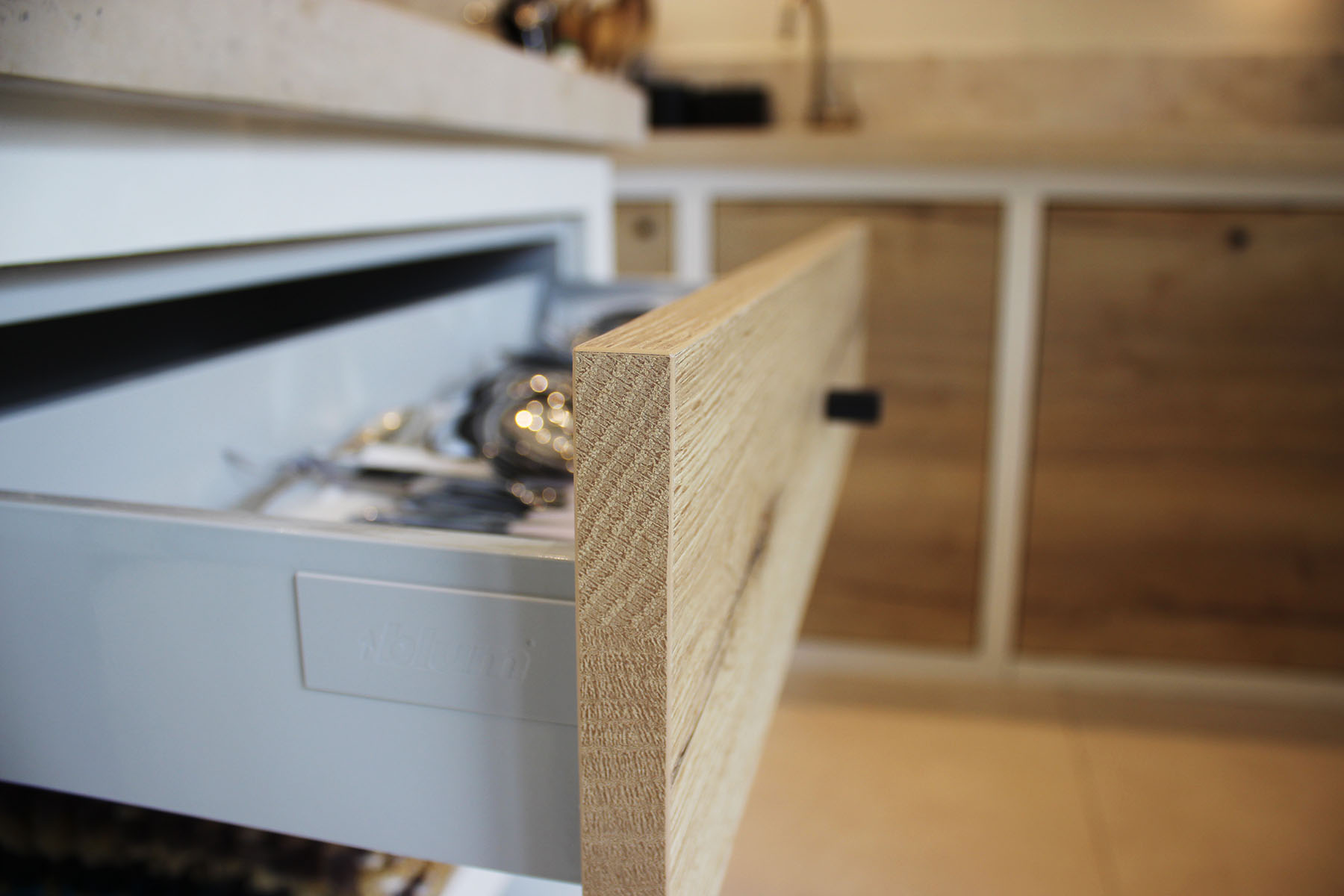 Façades — Décors chêne Halifax natural.
Bouton — Aluminium laqué noir.
+Produit — Chant de fil et chant de bout, pour un effet plus que réaliste.
Blum® — Qualité, fiabilité.