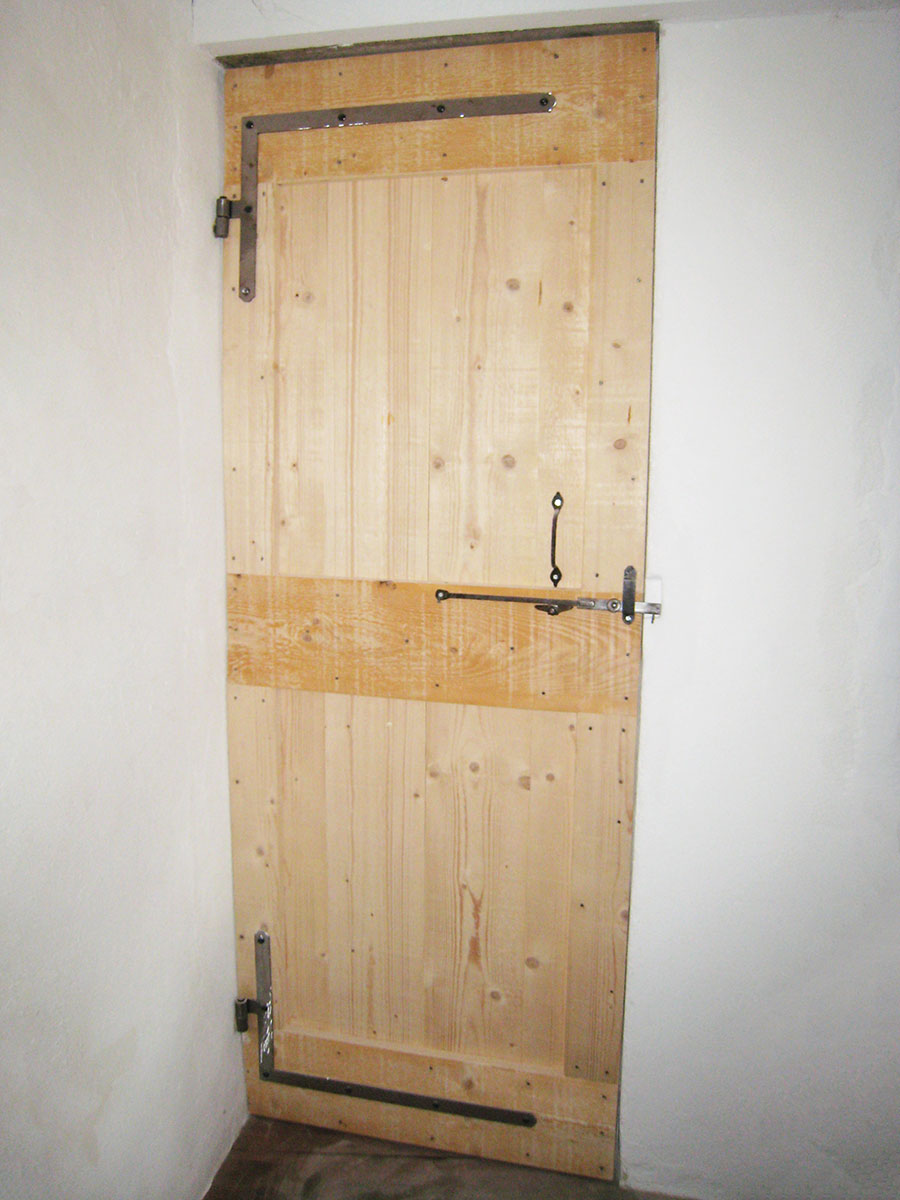 Porte — Épicéa à clous retournés.
Ferrures — Fer patiné.