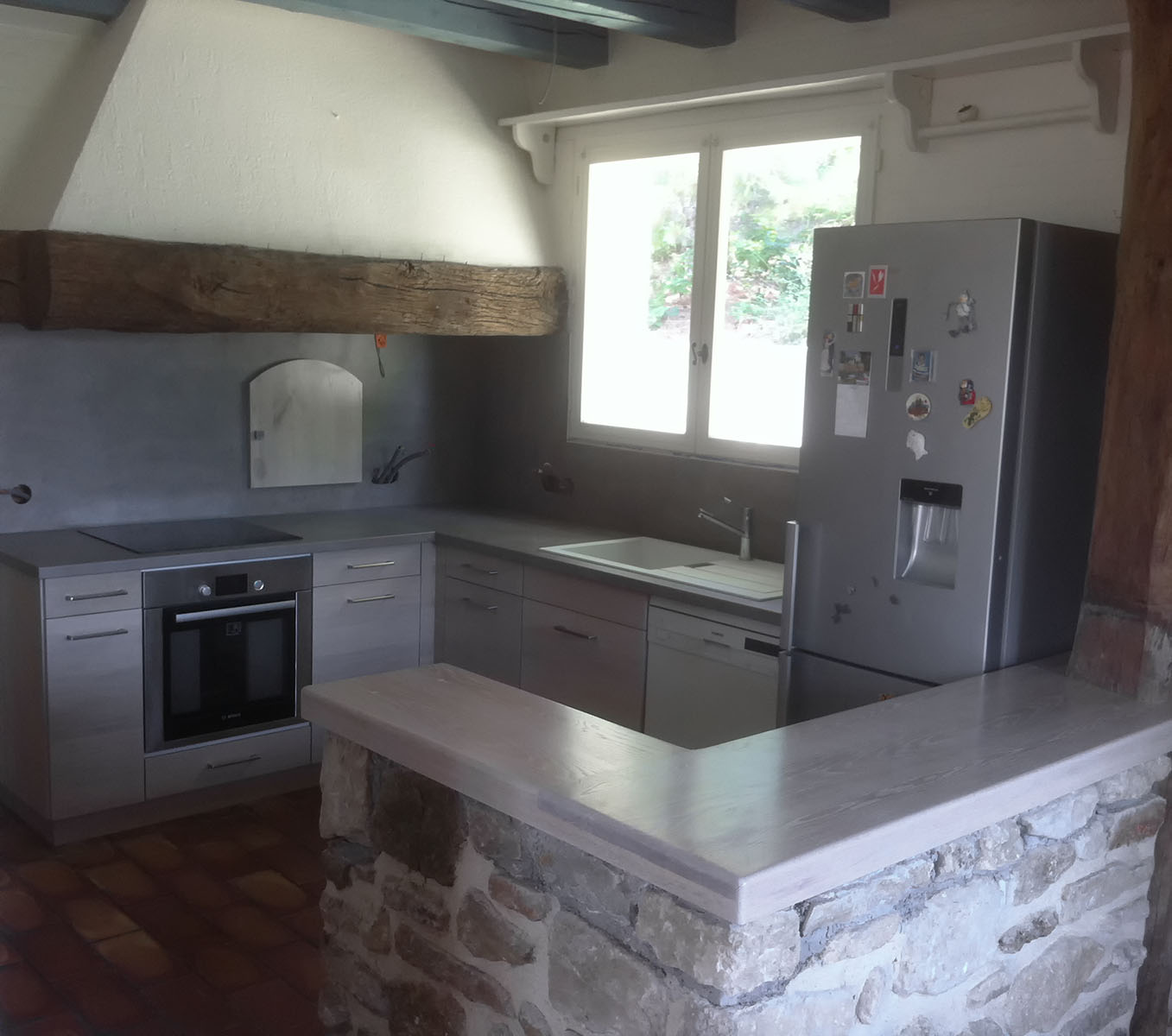 Façade — Chêne massif, tenté blanc, verni.
Plan de travail — Décor Stone.
Bar — Chêne massif, teinté blanc, vernis.
Evier encastré — Résine.
Electroménager — Four, plaque de cuisson, hotte, lave-vaisselle, frigo.