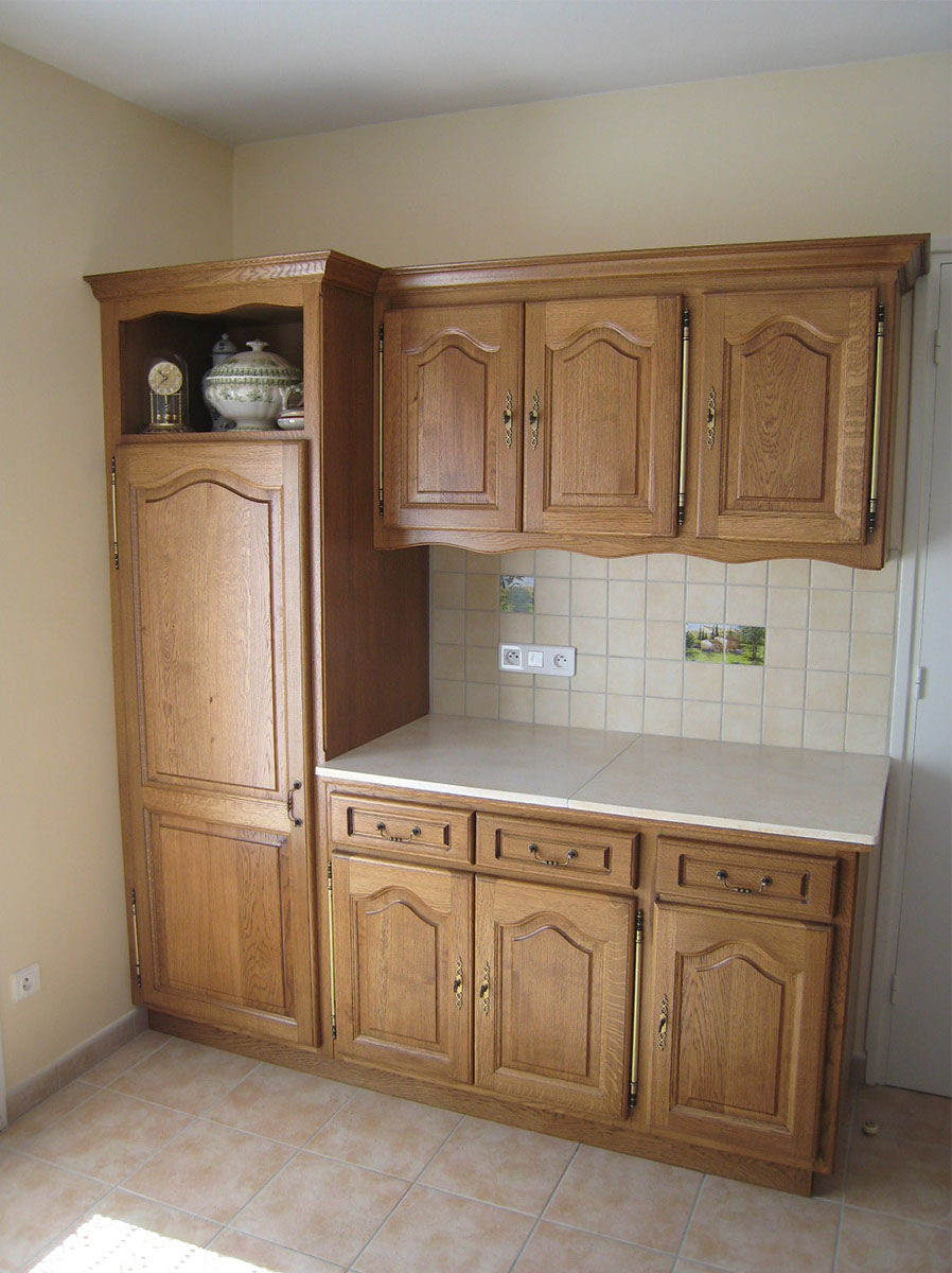 Façade — Chêne, teinté vernis.
Poignées — Serrures et poignées tombantes.
Plan de travail — Pierre de Mareuil.