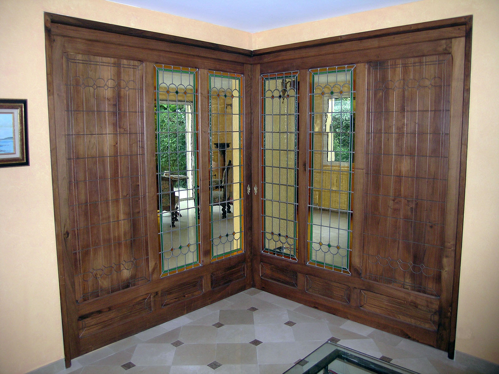 Porte coulissante — Noyer teinté, verni.
Vitrage — Vitraux traditionnels.