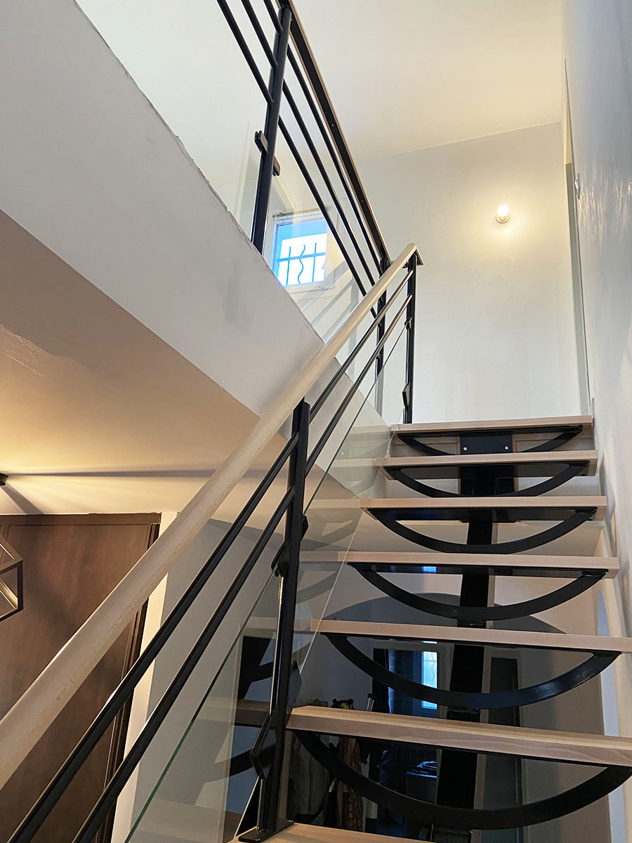 Marches et main courante — Hêtre.
Finition — Verni incolore.
Limon — Métal thermolaqué.
Garde corps — Verre et métal thermolaqué.